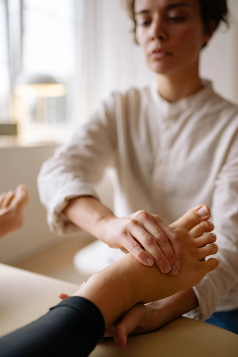 Podiatre qui manipule le pied d’une patiente