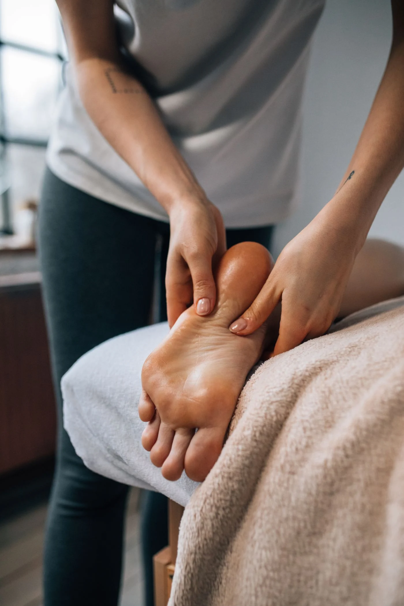 Podiatre qui masse la plante du pied d’un patient